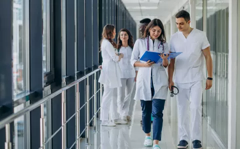 Student nurses walking through corridor of hospital